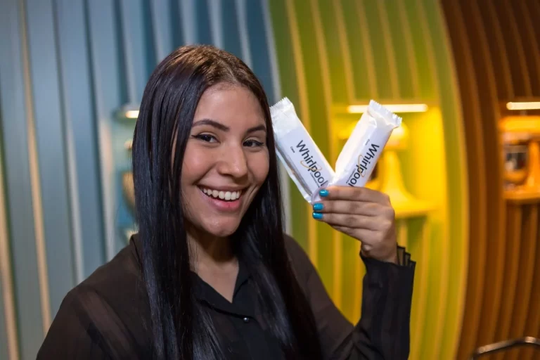 Mulher de cabelo preto sorrindo segurando dois picolés ilustrando o marketing de diferenciação.