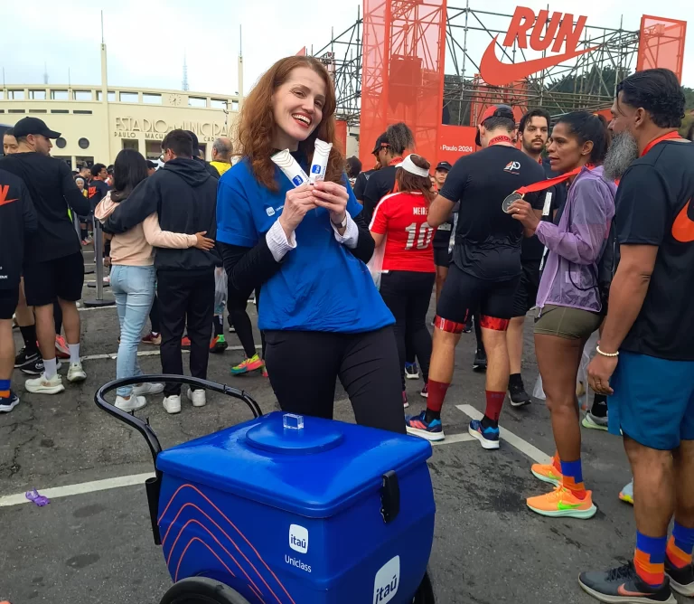 Promotora posando com picolés personalizados e carrinho de sorvete em evento esportivo da Nike Run