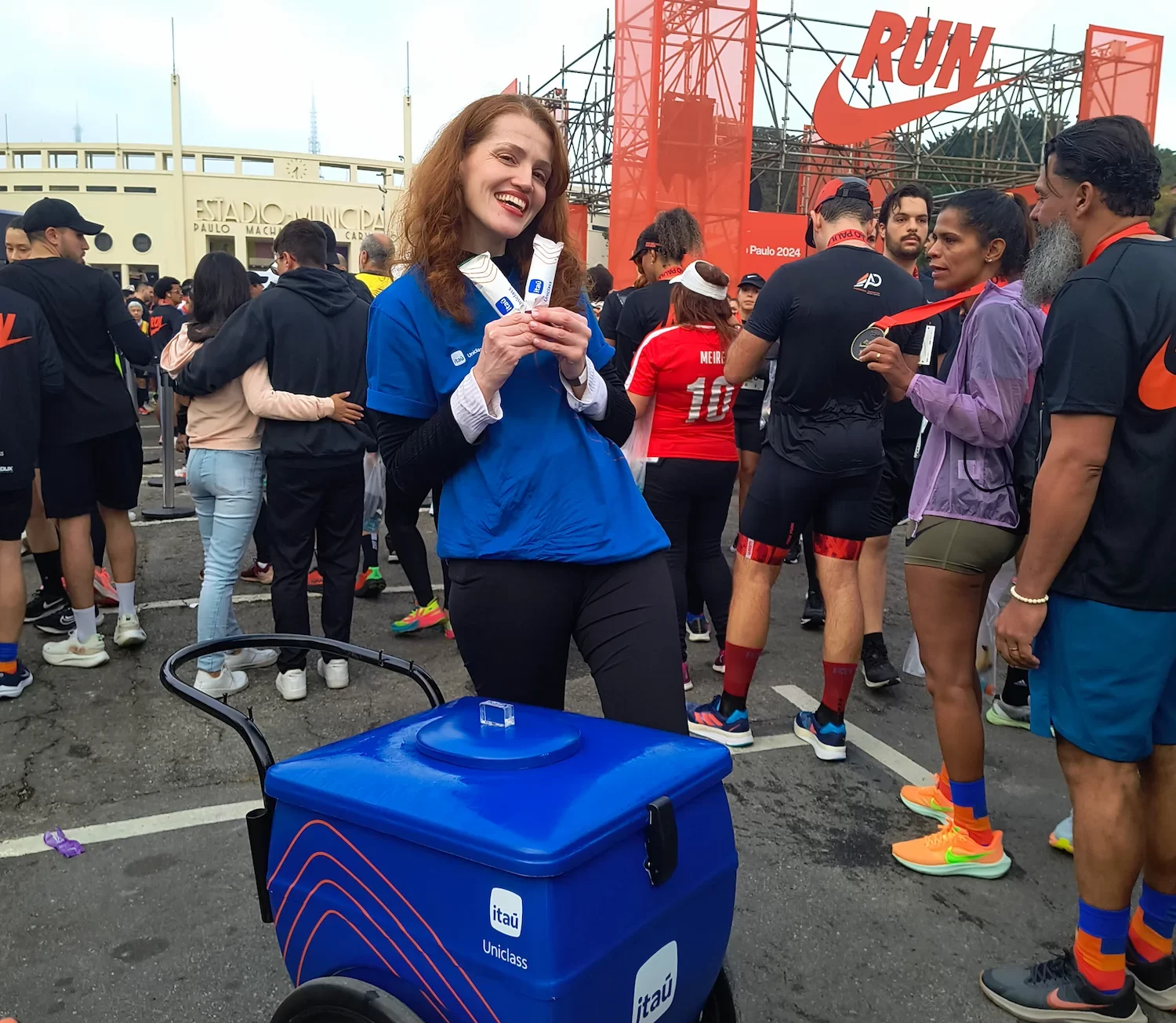 Promotora posando com picolés personalizados e carrinho de sorvete em evento esportivo da Nike Run